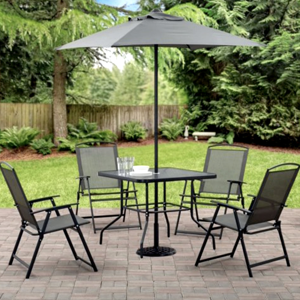 Gray patio dining set with umbrella on a garden lawn