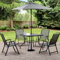 Gray patio dining set with umbrella on a garden lawn