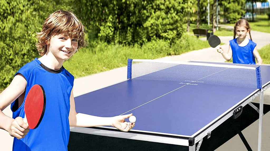 Kids playing ping pong outside on a sunny day
