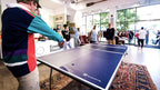 Group playing ping pong in a bright shared space