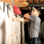 Young man hitting the red speed bag at home