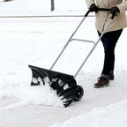 Man pushing snow along a path with the rolling snow pusher