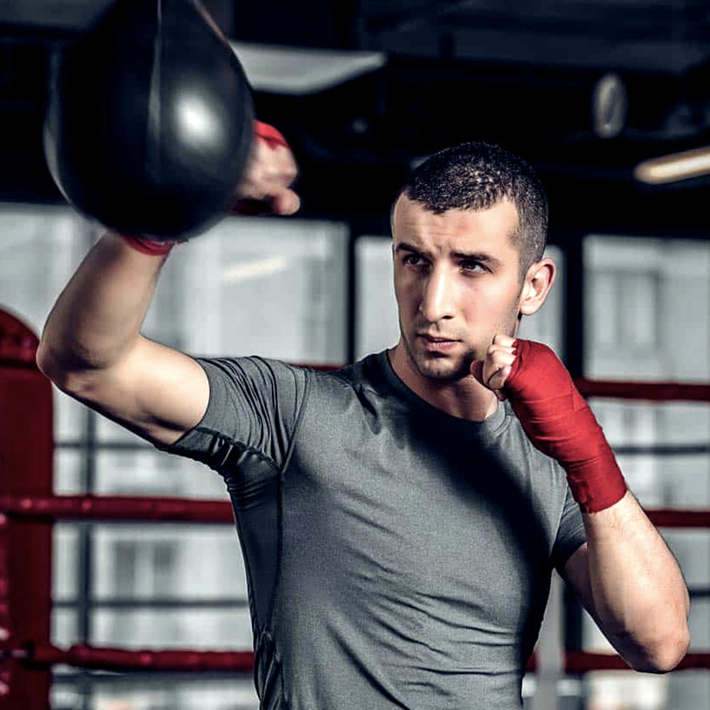 Man training on the speed bag in a boxing gym