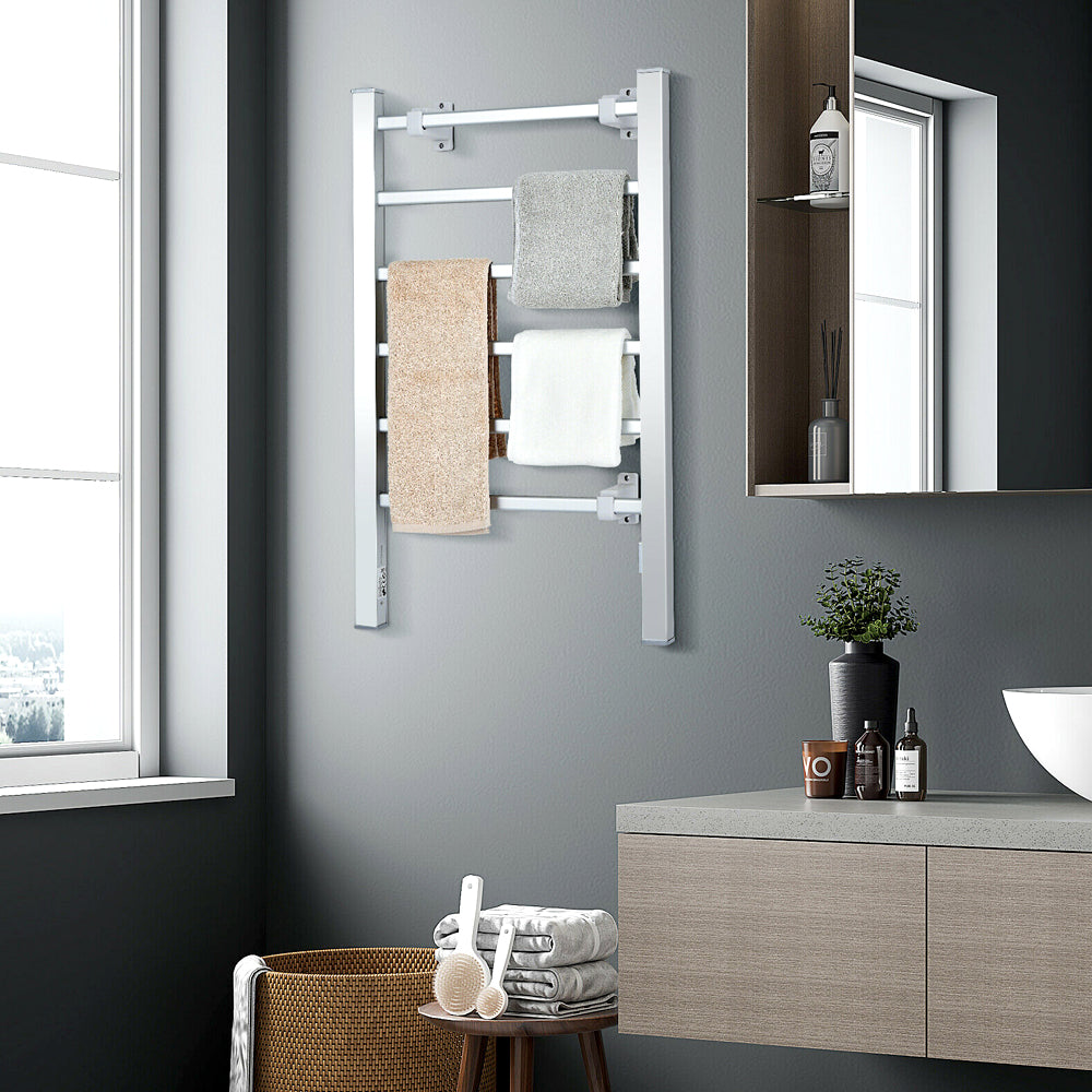 Silver heated towel warmer holding towels in a modern bathroom