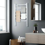 Silver heated towel warmer holding towels in a modern bathroom