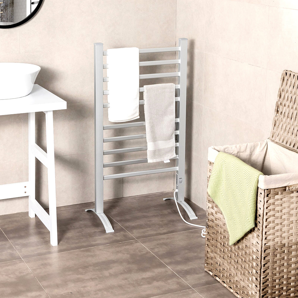 Freestanding towel warmer with towels beside a laundry basket