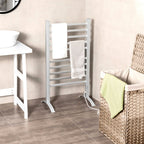 Freestanding towel warmer with towels beside a laundry basket