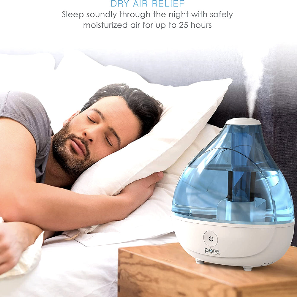 Humidifier misting on a nightstand beside a sleeping man