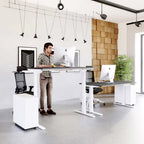 Two height-adjustable standing desks in a modern office