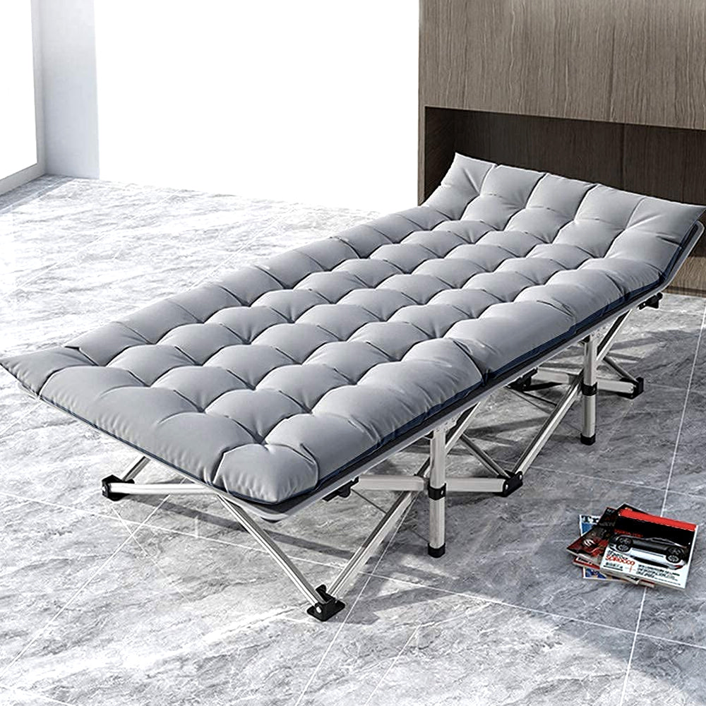 Folding cot with gray padded mattress in a living room