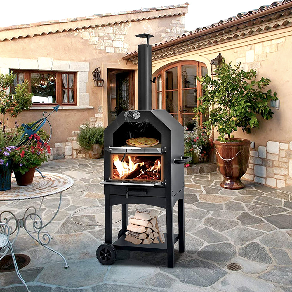 Wood-fired pizza oven on a stone patio with firewood stored below